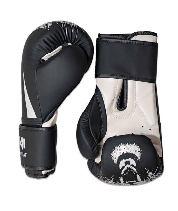 Ein Paar schwarz-weiße Boxhandschuhe mit einem grafischen Design, das ein schreiendes Gesicht zeigt.