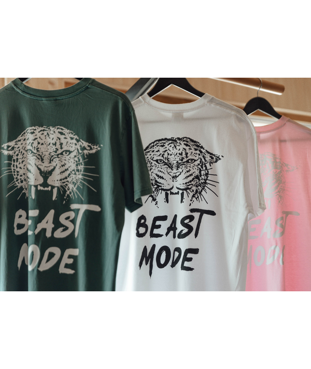 Drei T-Shirts auf Kleiderbügeln, jedes mit einem Leopardengesicht und dem Aufdruck 